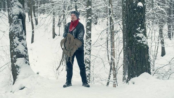 Tourist auf Schneeschanze sucht etwas im Rucksack - Foto, Bild
