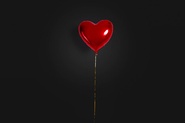 気球のセット。黒い背景に孤立した赤い色のハート型の箔風船の束。愛だ。お祝いだ。バレンタインデーのパーティーの装飾。メタリックレッドハートエアバルーン - 写真・画像