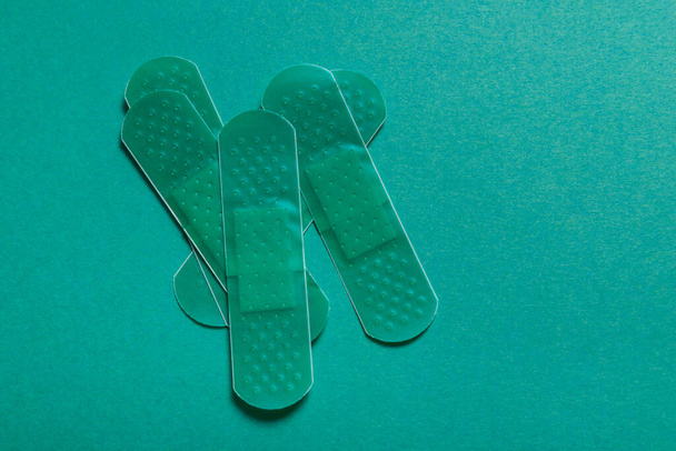 Set of colored first aid plasters on color background - Foto, afbeelding
