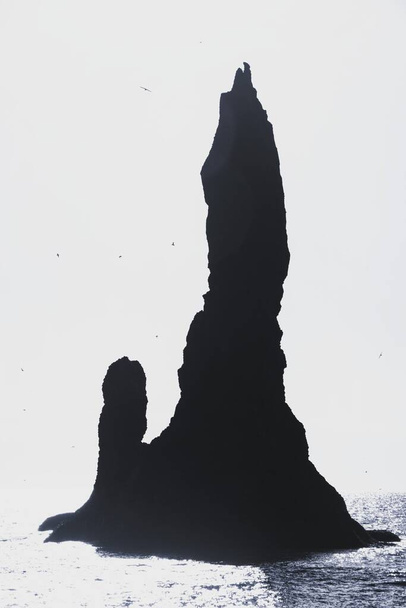 Reynisdrangar базальтовый морской стек скалы образования Атлантического океана побережье на вулканическом пляже черный песок Reynisfjara Вик Исландия - Фото, изображение