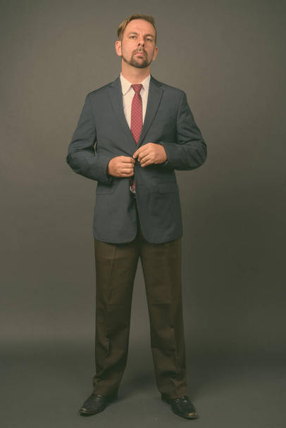 Blond bearded businessman with goatee against gray background - Фото, зображення