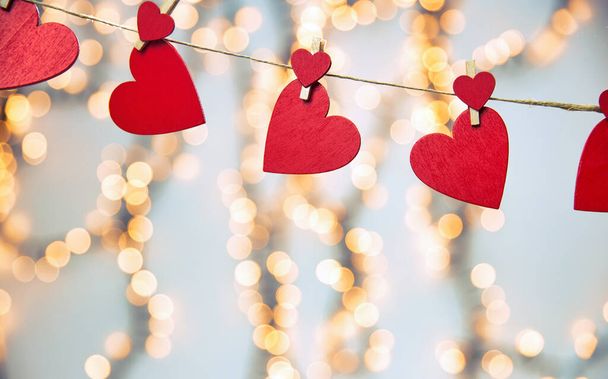 Happy Valentine day background with red hearts hang with clothespin on rope with bokeh background, romantic design, greeting card or copy space - Photo, Image