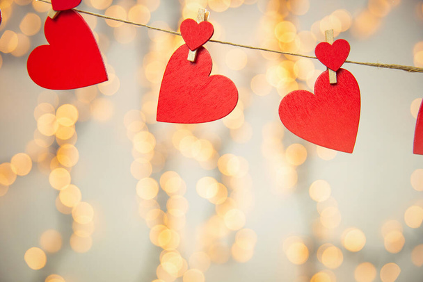Šťastný Valentýn pozadí s červenými srdci visí s kolíkem na laně s bokeh pozadí, romantický design, přání nebo kopírovat prostor - Fotografie, Obrázek