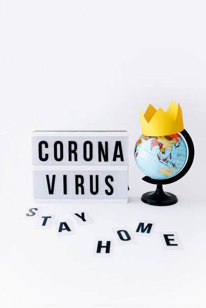 Concetto di Covid 19, Corona testo del virus in mostra in lightbox e globo con corona su di esso, sfondo chiaro. - Foto, immagini