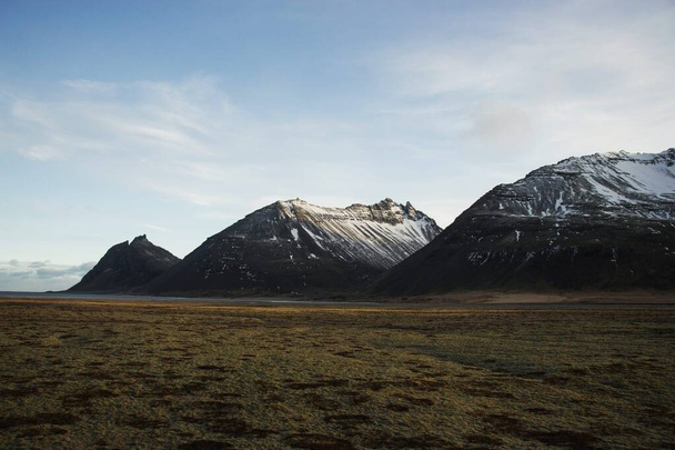 Vue panoramique d'une chaîne de montagnes couvertes de neige typique nature paysage hivernal en Islande Europe - Photo, image