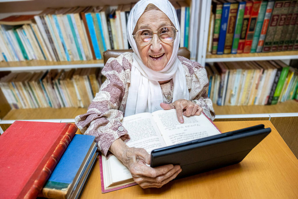 Arabia muslimi nainen käyttää kannettavaa tietokonetta lukemiseen E-kirjoja nad surfing internet - Valokuva, kuva
