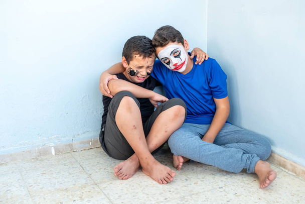 Dos hermanos sentados en la esquina sintiéndose enfadados - Foto, imagen