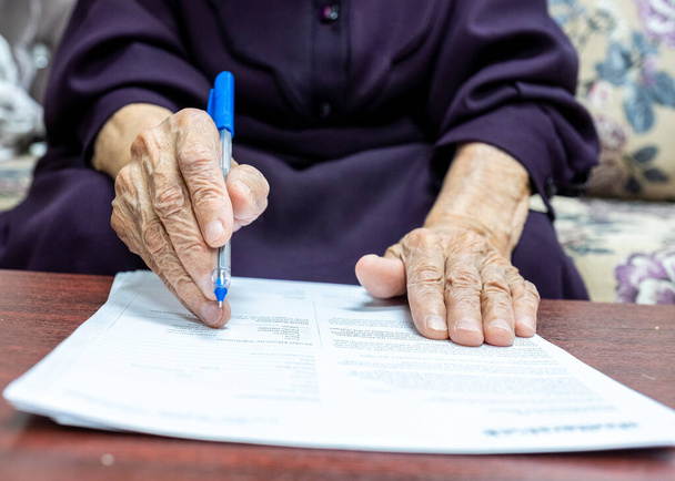 Old muslim woman signing some documents - Zdjęcie, obraz