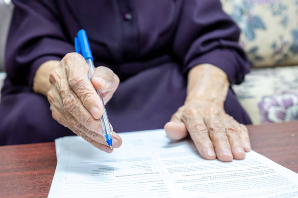 Egy öreg muszlim nő aláírta a papírokat. - Fotó, kép