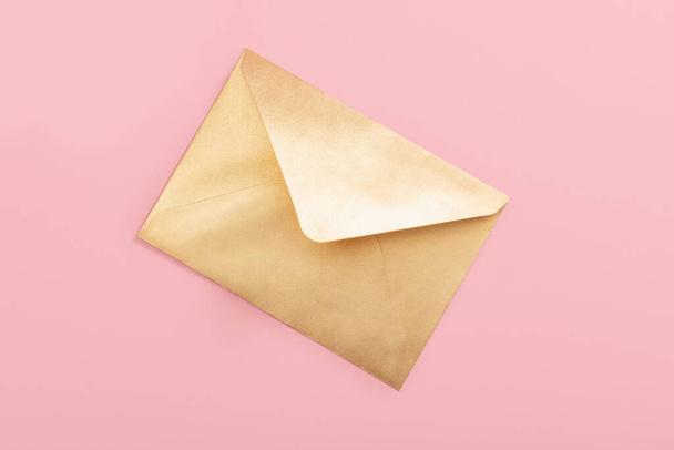 Golden paper envelope isolated on pink background - Fotoğraf, Görsel