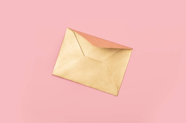 Golden paper envelope isolated on pink background - Fotó, kép