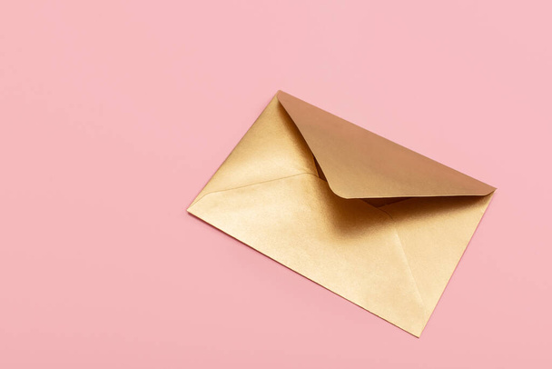 Golden paper envelope isolated on pink background - Foto, Imagen
