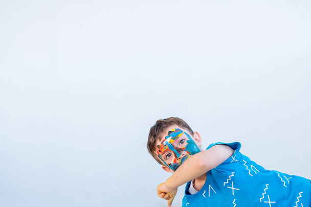 Jongen spelen met kleuren met behulp van zijn handen en zijn gezicht - Foto, afbeelding