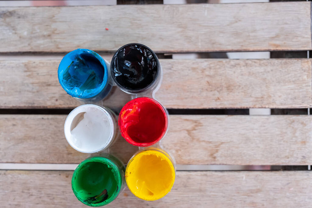 Τραπέζι με διάφορα χρώματα ζωγραφικής πάνω του - Φωτογραφία, εικόνα