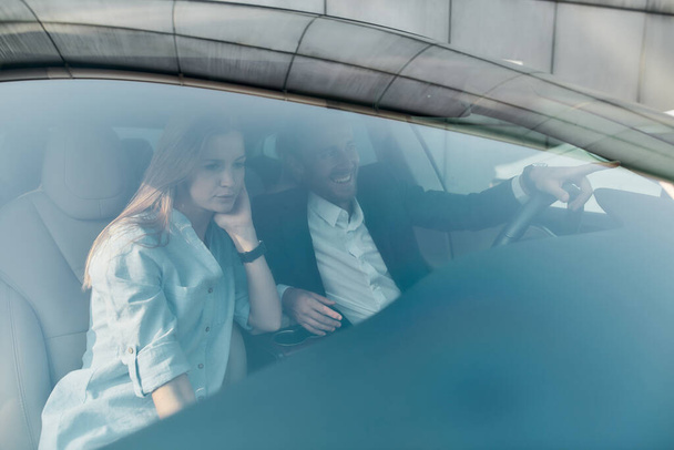 Young caucasian couple sitting in car behind wind window - Foto, Imagem
