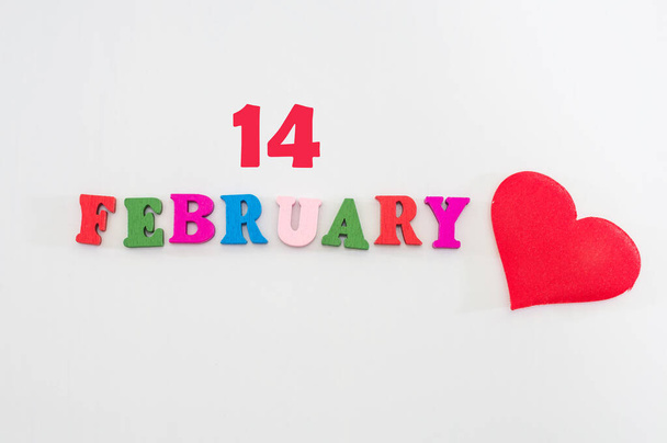 Η λέξη 14 Φεβρουαρίου με κόκκινη καρδιά σε λευκό φόντο. Έννοια Ημέρα του Αγίου Βαλεντίνου. - Φωτογραφία, εικόνα
