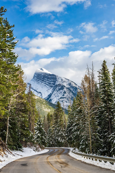 Заснеженная гора Рандл со снежной лесной горной дорогой. Маунт Норки Сценический Драйв. Национальный парк Банф красивый пейзаж зимой. Canadian Rockies, Альберта, Канада. - Фото, изображение