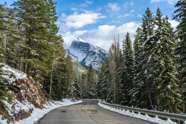 Snow-covered Mount Rundle with snowy forest mountain road. Mount Norquay Scenic Drive. Banff National Park beautiful landscape in winter. Canadian Rockies, Alberta, Canada. - Foto, imagen