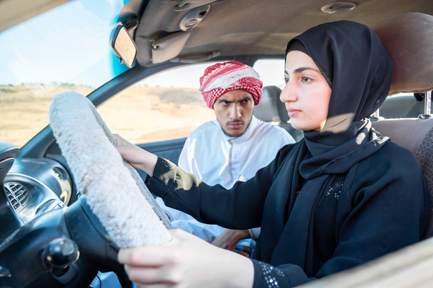 arabski mężczyzna uczy arabski kobieta jazdy - Zdjęcie, obraz