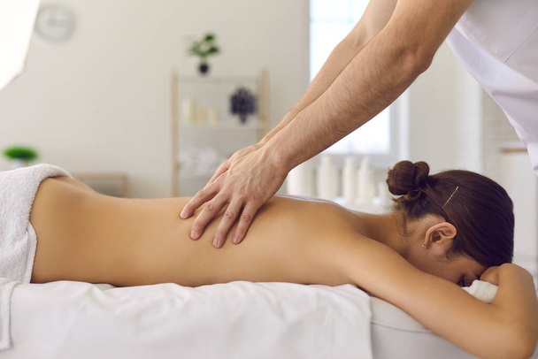 Masseur making acupressure or relaxing massage of back woman - Фото, изображение