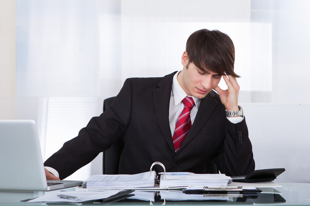 Businessman Suffering From Headache While Calculating Finance - Foto, Imagem