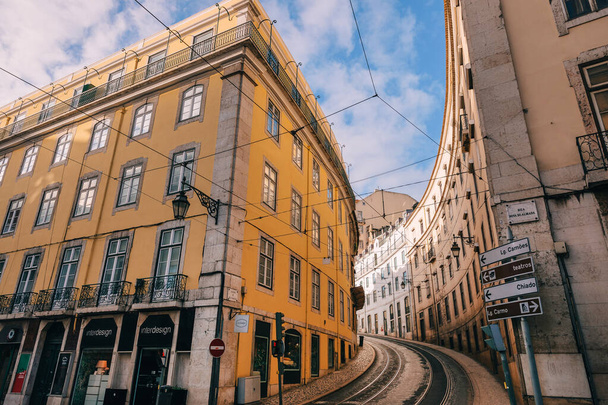 Lisboa, Portugal - 27 de janeiro de 2019 - bela arquitetura de edifícios com vitrines. a rua com trilhos de bonde e pavimento sobe. Lisboa, Portugal. - Foto, Imagem