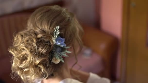 krásný účes s květy blond nevěsty při pohledu na sebe v zrcadle - Záběry, video
