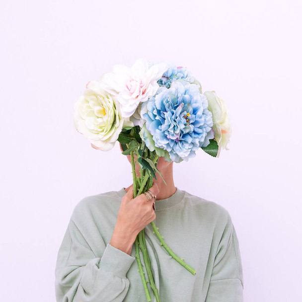 Girl Holding bouquet In Front Of Her Face in stylish casual fresh look. Spring summer collection. Minimalist - Foto, Imagem
