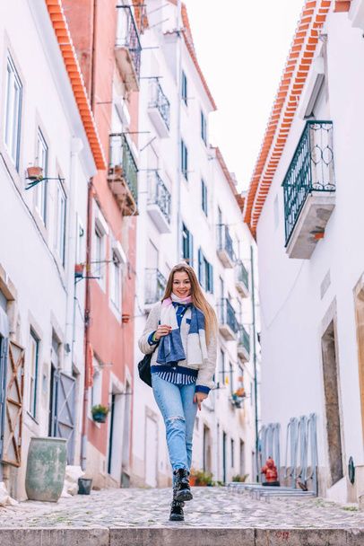 A young traveler walks along the beautiful old cozy street of Lisbon in Portugal. - Fotoğraf, Görsel