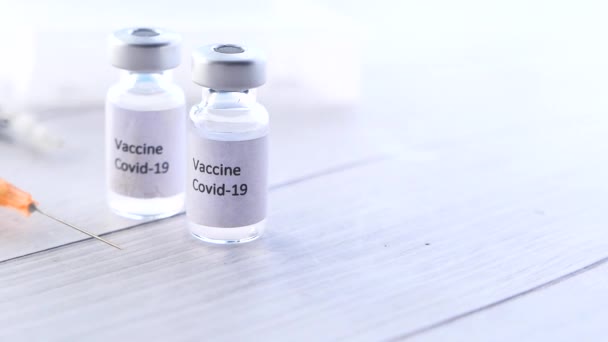 Gros plan du vaccin contre le coronavirus et de la seringue sur fond blanc - Séquence, vidéo