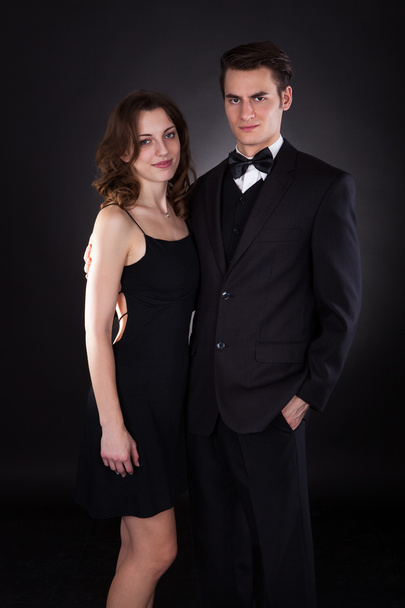 Elegant Couple Standing Over Black Background - Fotoğraf, Görsel