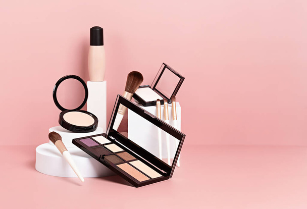 Maquillaje de productos prentado en podios blancos sobre fondo pastel rosa. Mockup para presentación de marca y embalaje - Foto, Imagen