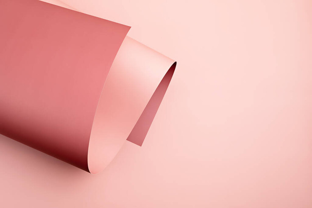 Abstract backgroud of rolled textured paper sheet of different shades of pink. Close up of geometric abstract forms - 写真・画像