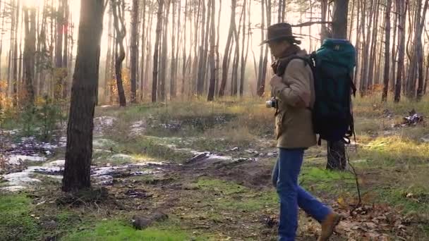 Un hombre con cámara camina por un sendero en el bosque - Imágenes, Vídeo