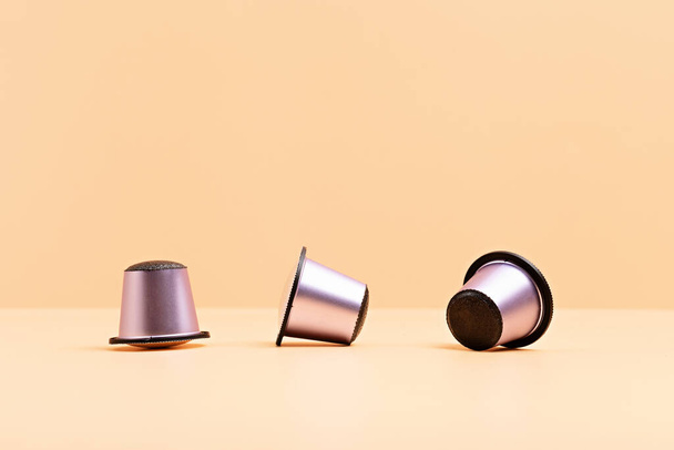 Disposable coffee capsules over beige background with copy space. Morning dose of caffeine, energy, flavor concept. Mockup, copy space - Photo, Image
