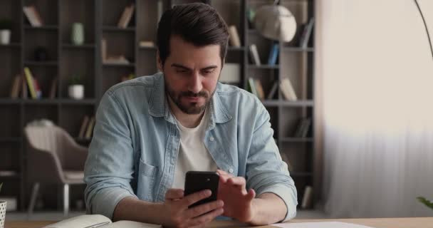 Excited man holding smartphone feels happy by great sms news - Video, Çekim