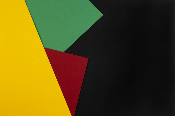 Февраль месяц чёрной истории. Аннотация Paper geometric black, red, yellow, green background. Скопируй место, место для текста. Вид сверху. - Фото, изображение