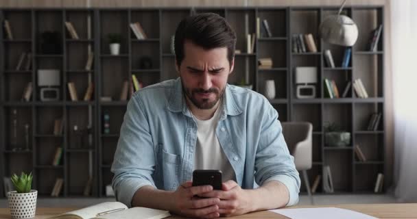 Businessman holding smartphone feels by irritated by received bad news - Video, Çekim
