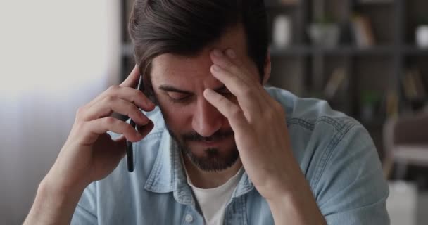 Man feels upset listening bad news on the phone - Πλάνα, βίντεο