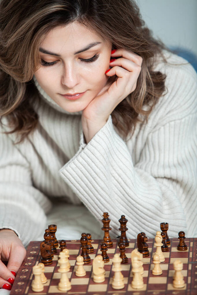 Beautiful girl  playing chess at home.  - Photo, Image