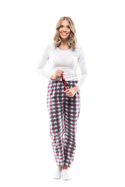 Confident happy young pretty woman getting ready for sleep getting dressed in pajamas. Full body length isolated on white background.  - Photo, Image