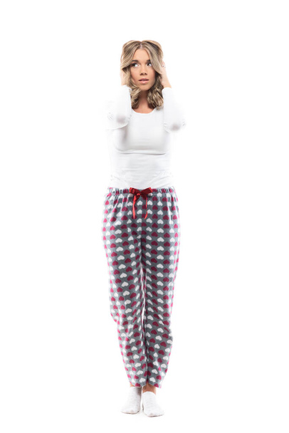 Distressed worried young pretty woman in pajama touching head looking away emotionally. Full body length isolated on white background.  - Zdjęcie, obraz