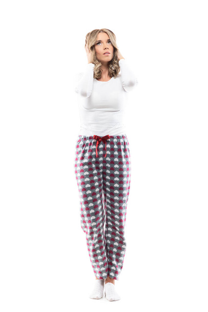 Beauty girl in pajamas touching head suffer from headache looking up sad. Full body length isolated on white background.  - Photo, Image