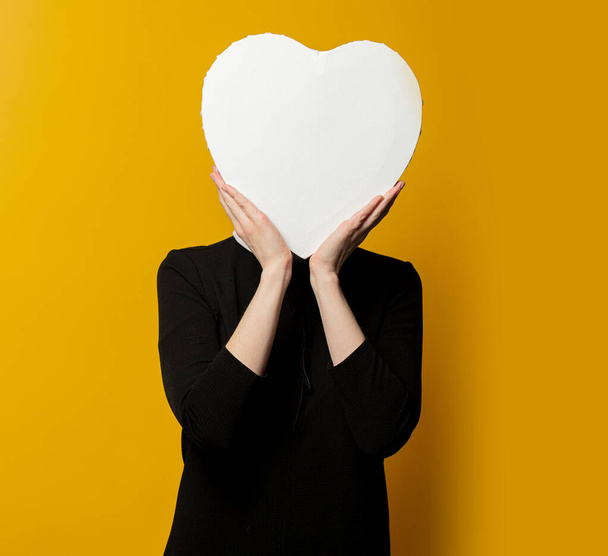 Mujer con forma de corazón maqueta sobre fondo amarillo  - Foto, Imagen