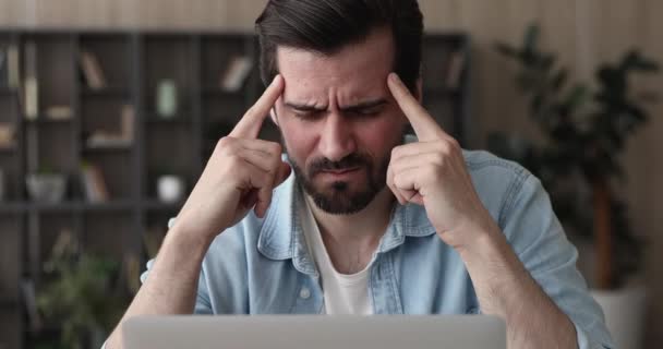 Man sit indoor closed eyes rub temples suffering from headache - Filmmaterial, Video