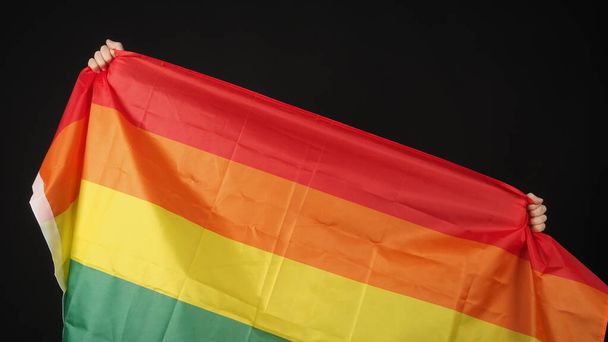Bandeira LGBTQ ou lésbica gay bi sexual transexual queer ou orgulho homossexual bandeira do arco-íris no fundo preto. Representar símbolo de mão de liberdade, paz, igualdade e amor. Conceito LGBTQ - Foto, Imagem