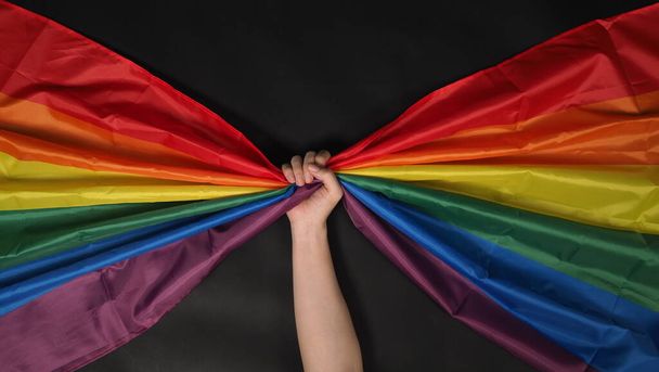 σημαία ΛΟΑΤΚΙ ή λεσβιακή γκέι bi sexual τρανσέξουαλ queer ή ομοφυλοφιλική υπερηφάνεια σημαία ουράνιο τόξο σε μαύρο φόντο. Αναπαραστήστε το σύμβολο της ελευθερίας, της ειρήνης, της ισότητας και της αγάπης. LGBTQ έννοια - Φωτογραφία, εικόνα