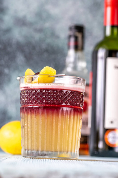 Стакан нью-йоркской сауэр украшен коктейльной вишней и лимонной кожурой - Фото, изображение