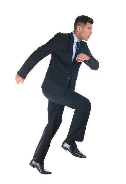 Businessman imitating stepping up on stairs against white background. Career ladder concept - Photo, Image
