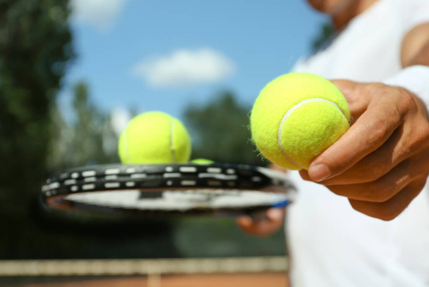Sportsman with racket and tennis balls at court, closeup - Fotoğraf, Görsel